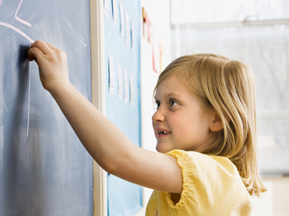 Child pointing at a blackboard